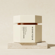 Mască de păr Honeyque Night Repair Premium Mask 220 g, pe podium din piatră, în decor de studio ivoire.